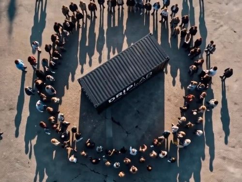 Luchtfoto van een DRIPLAB pop-up container omringd door bezoekers op een festivalterrein